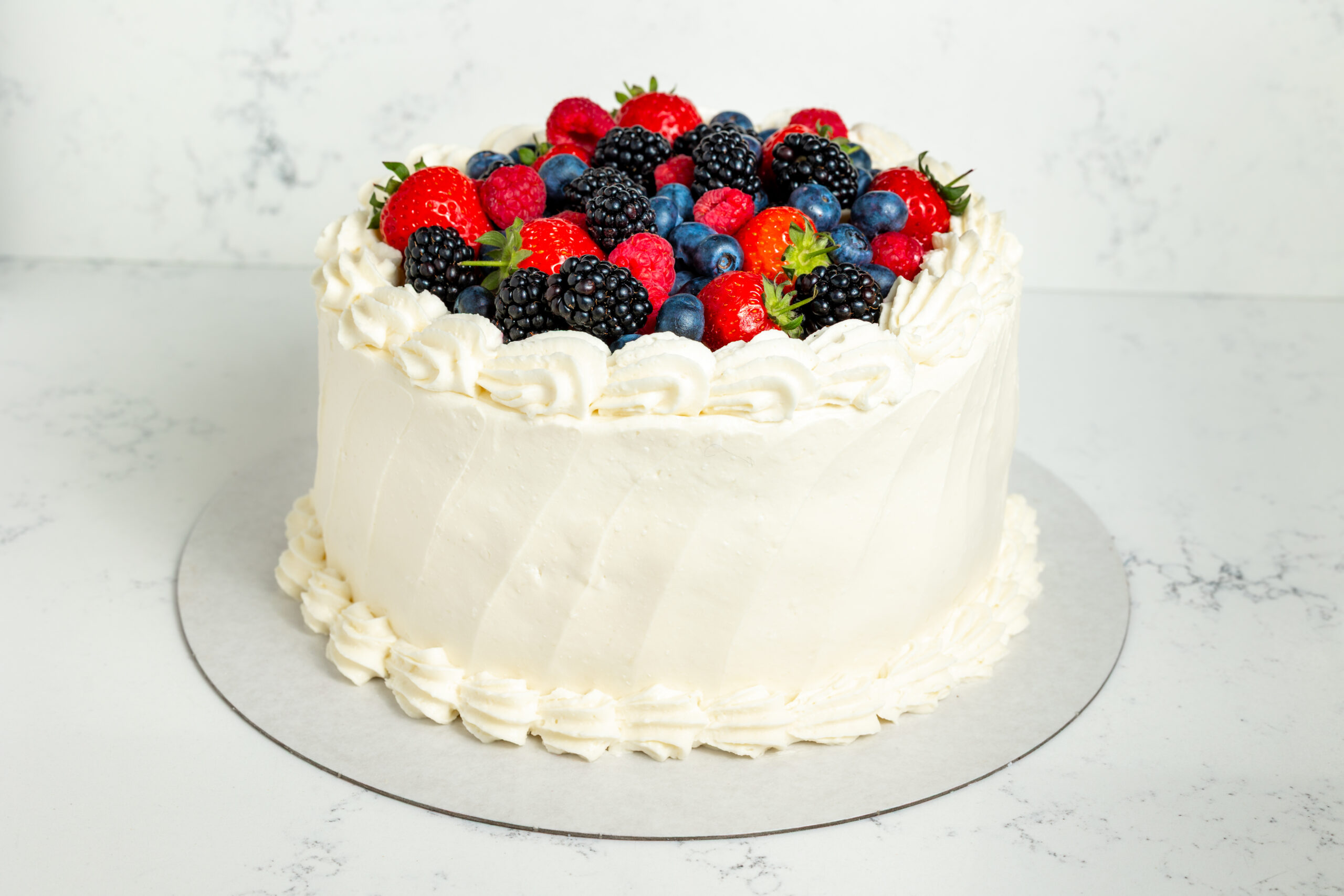 White fruit cake with strawberries, blueberries and blackberries