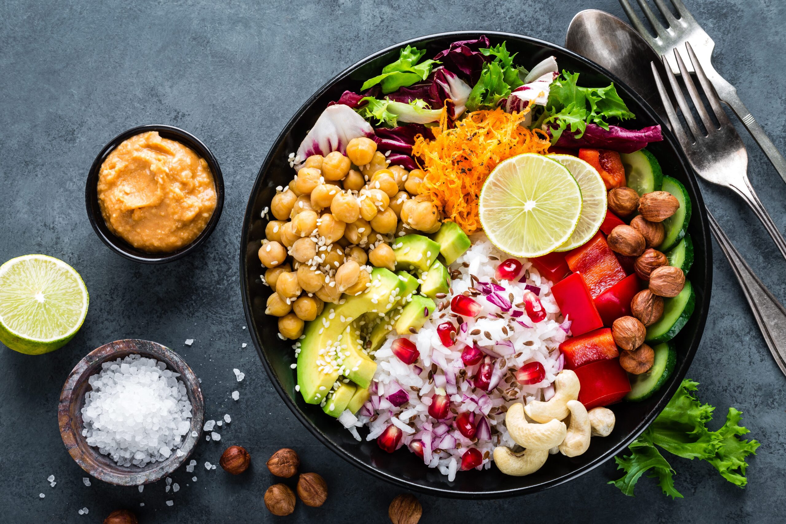 Colourful healthy salad bowl with chickpeas, beetroot, lime, and fresh greens.